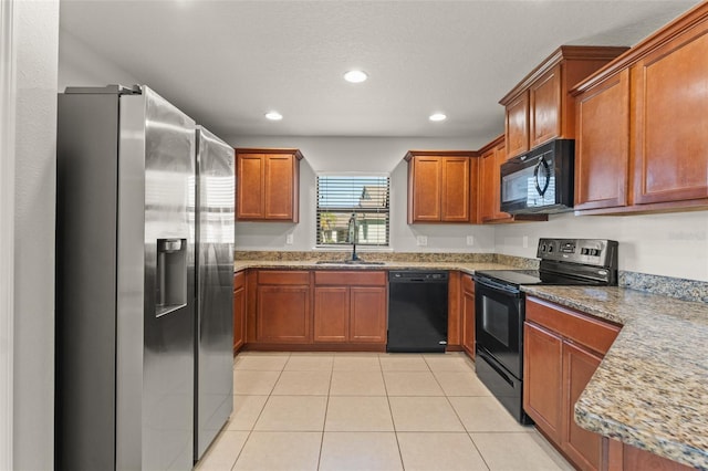 kitchen with a sink, black appliances, light tile patterned flooring, and recessed lighting