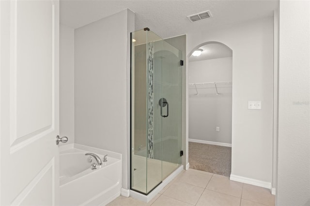 full bath featuring visible vents, a shower stall, a spacious closet, a garden tub, and tile patterned floors