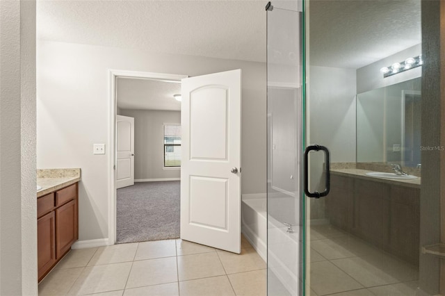 bathroom featuring tile patterned floors, a shower with shower door, a textured ceiling, and vanity