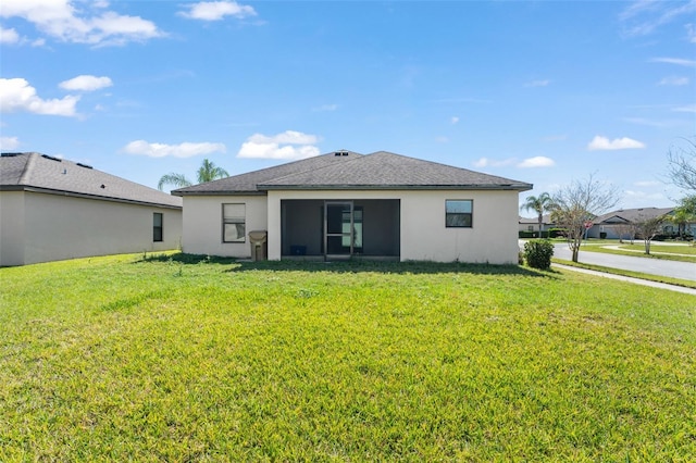 back of house featuring a yard and stucco siding