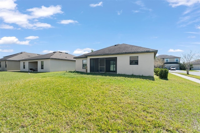 rear view of property with a yard and stucco siding