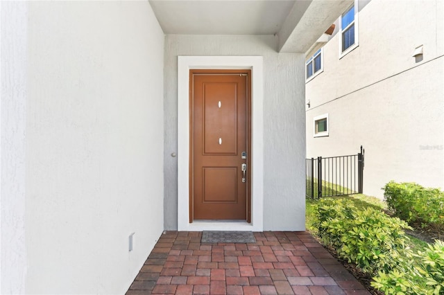 doorway to property featuring stucco siding