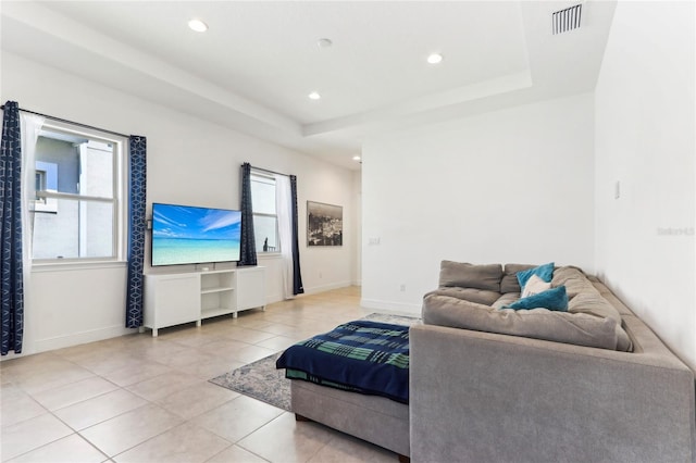 living room with light tile patterned floors, baseboards, a raised ceiling, and recessed lighting