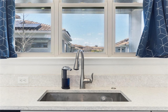 room details with glass insert cabinets, light countertops, and a sink