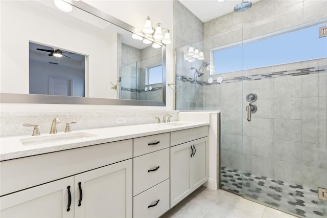 full bathroom with a shower stall, double vanity, tile patterned floors, and a sink