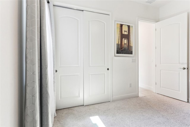 unfurnished bedroom with a closet, baseboards, and carpet