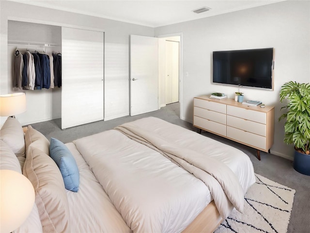 carpeted bedroom featuring visible vents, baseboards, and a closet