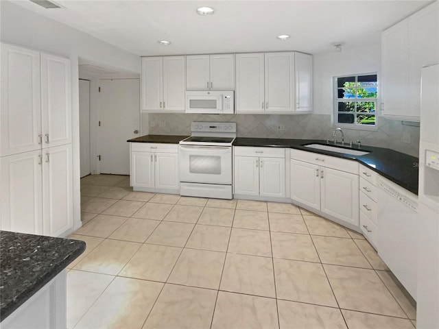 kitchen with white appliances, white cabinets, light tile patterned floors, and a sink