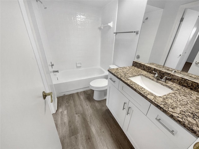 bathroom with vanity, toilet, wood finished floors, and shower / bath combination