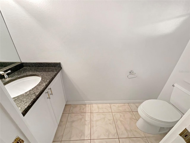 bathroom featuring baseboards, toilet, and vanity