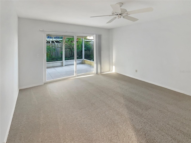 carpeted empty room with baseboards and a ceiling fan