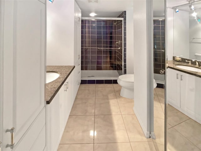 full bathroom featuring tile patterned flooring, visible vents, toilet, a tile shower, and vanity