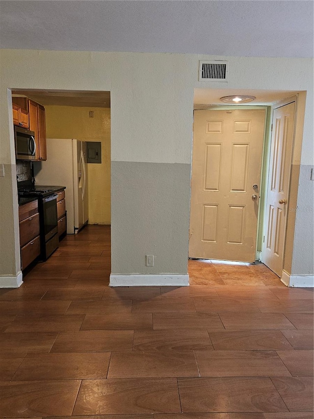 interior space with visible vents, gas range, wood tiled floor, and stainless steel microwave