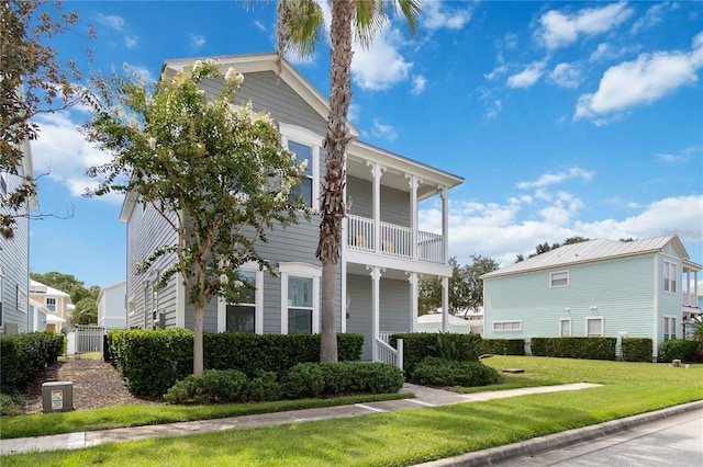 view of front of house featuring a balcony and a front yard