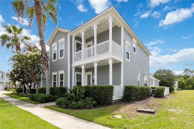 view of front of home featuring a balcony and a front yard