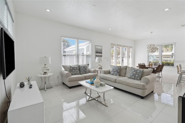 living area with light tile patterned flooring, recessed lighting, baseboards, and a textured ceiling