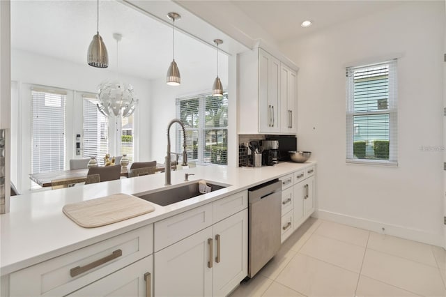 kitchen with dishwasher, light countertops, light tile patterned floors, white cabinetry, and a sink