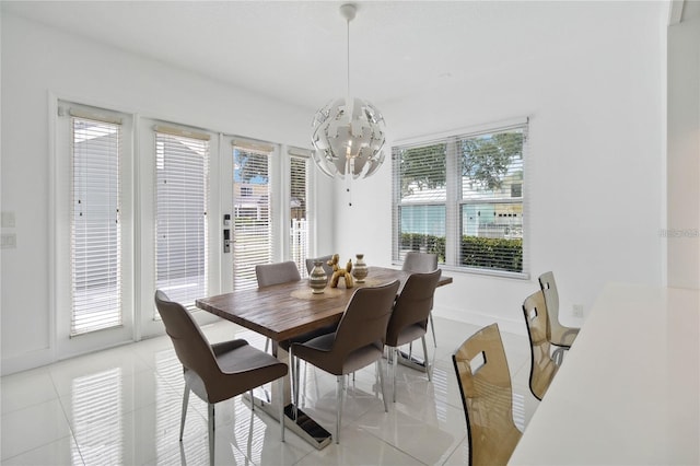 dining area with french doors, baseboards, a notable chandelier, and light tile patterned flooring