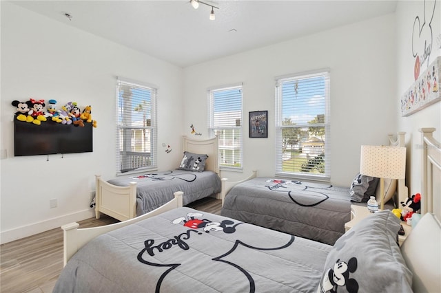 bedroom with baseboards and wood finished floors