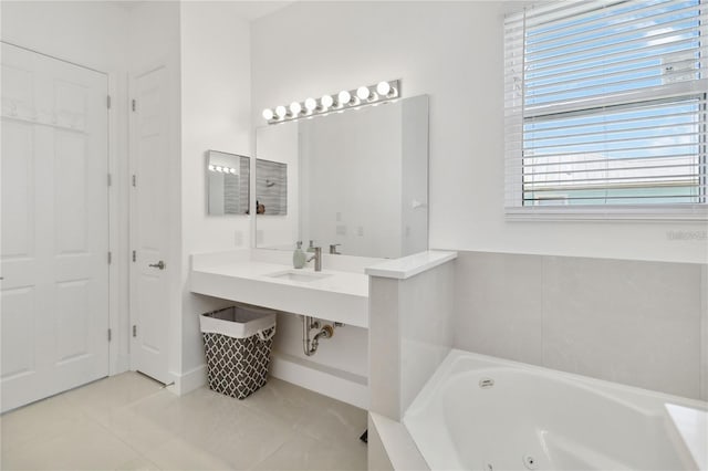 bathroom featuring tile patterned floors, a jetted tub, and a sink