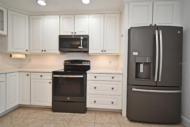 kitchen featuring light countertops, white cabinets, stainless steel fridge, and range with electric cooktop