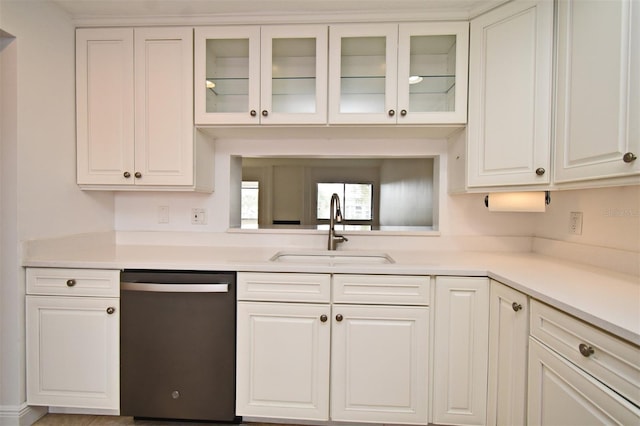 kitchen featuring a sink, dishwasher, white cabinets, and light countertops