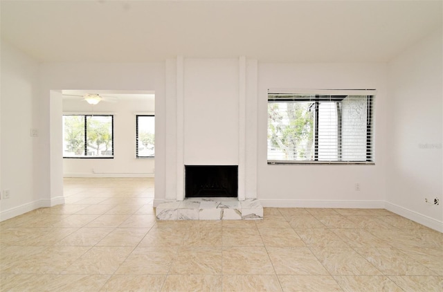 unfurnished living room with tile patterned floors, baseboards, and a fireplace