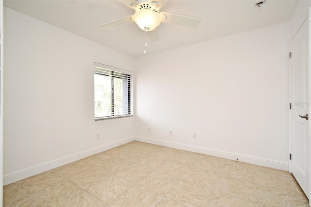 empty room featuring a ceiling fan and baseboards