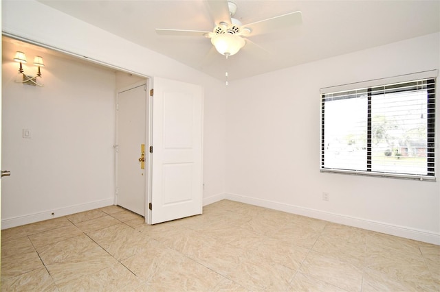 empty room with light tile patterned floors, baseboards, and a ceiling fan