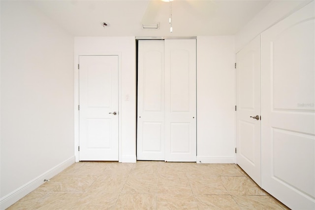 unfurnished bedroom with baseboards and a closet