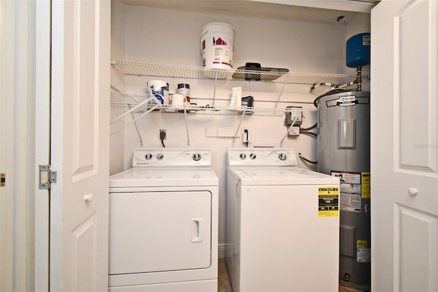 laundry room featuring laundry area, electric water heater, and separate washer and dryer