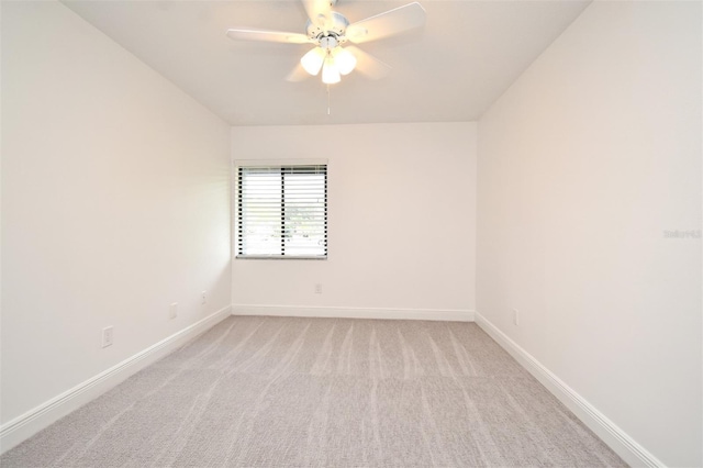 empty room with baseboards, light carpet, and a ceiling fan