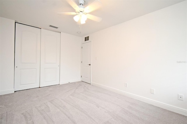 unfurnished bedroom with visible vents, baseboards, light colored carpet, and a closet