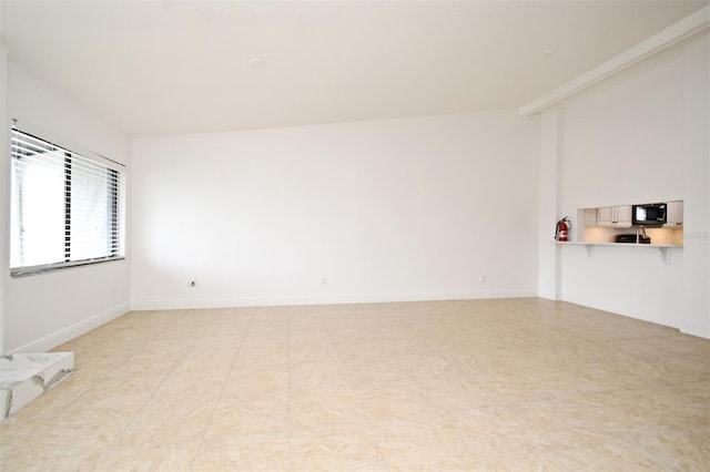 empty room with lofted ceiling and baseboards