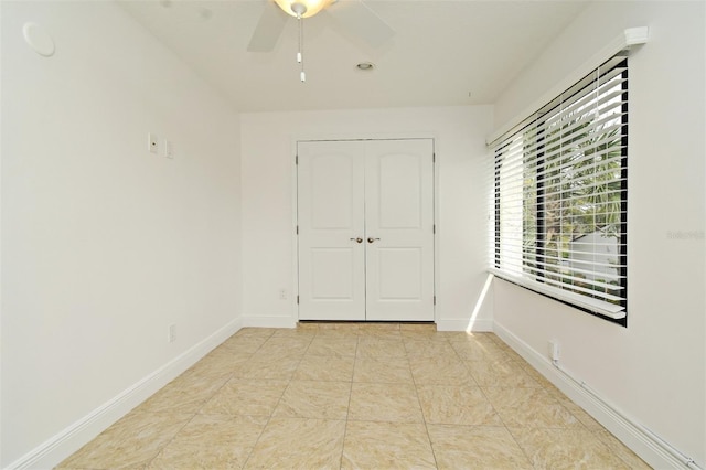 empty room featuring baseboards and a ceiling fan