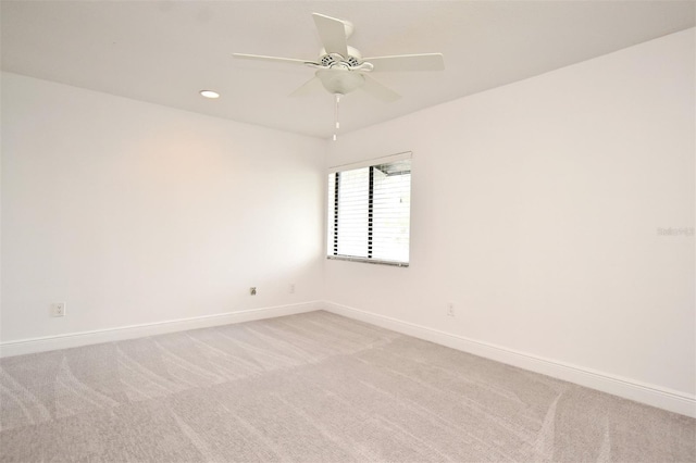 spare room featuring ceiling fan, recessed lighting, baseboards, and light carpet