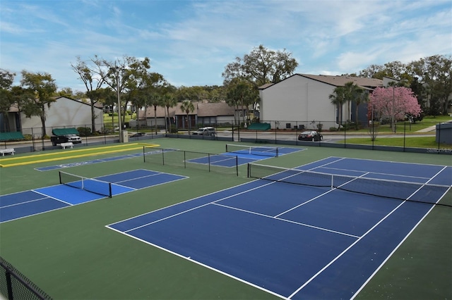 view of tennis court with community basketball court and fence