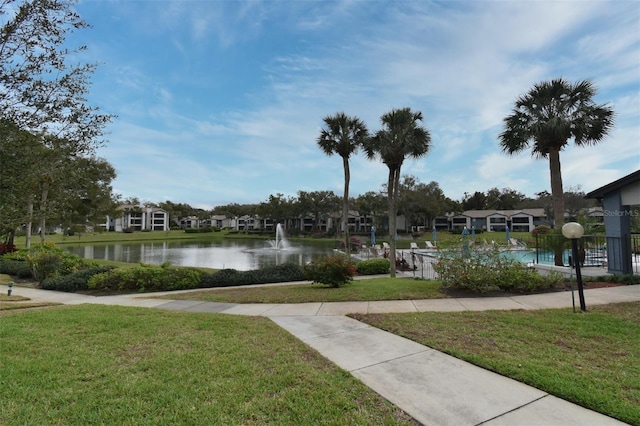 view of property's community with a yard and a water view