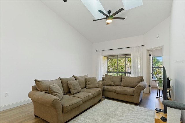 living room featuring baseboards, high vaulted ceiling, light wood-style floors, and a ceiling fan