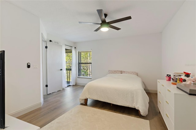 bedroom featuring light wood finished floors, baseboards, and ceiling fan