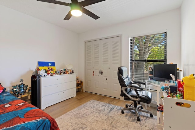 bedroom featuring ceiling fan, a closet, and wood finished floors