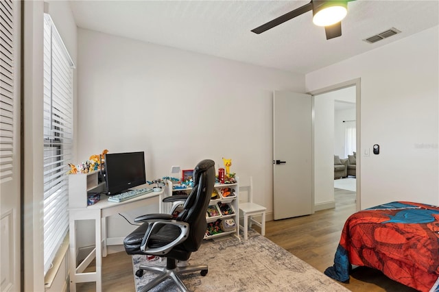 bedroom featuring visible vents, a ceiling fan, and wood finished floors