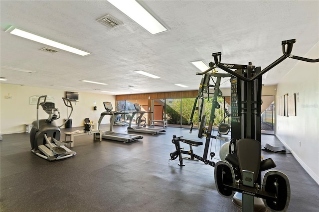 workout area with visible vents, baseboards, and a textured ceiling