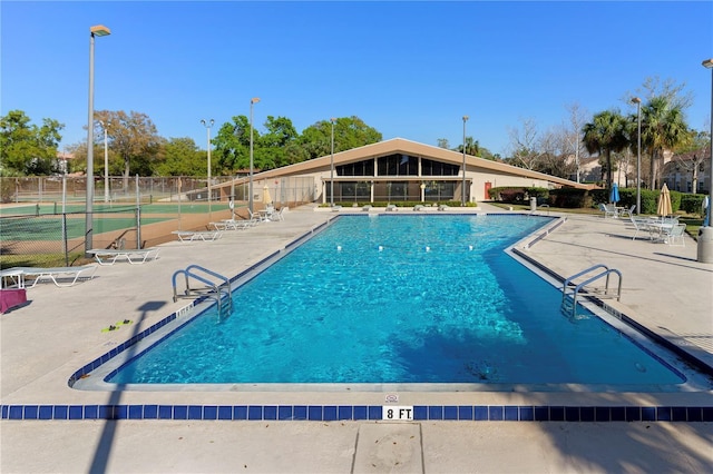 community pool featuring a patio area and fence