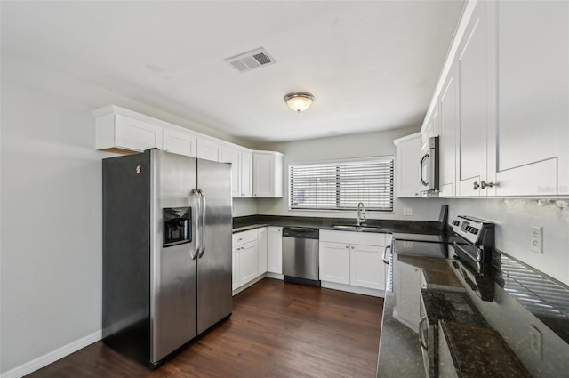 kitchen featuring visible vents, appliances with stainless steel finishes, dark wood-type flooring, and a sink