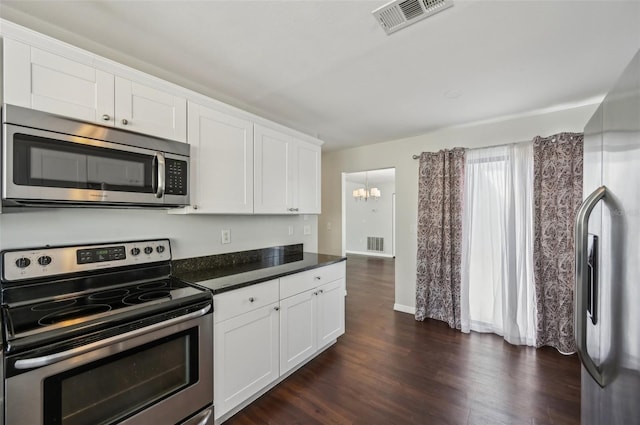 kitchen featuring dark countertops, a notable chandelier, visible vents, and stainless steel appliances