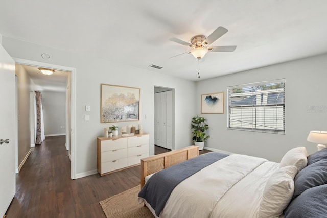 bedroom featuring a ceiling fan, wood finished floors, visible vents, baseboards, and a closet