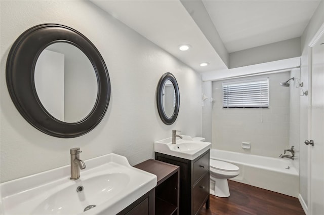 bathroom with a sink, toilet, shower / washtub combination, and wood finished floors