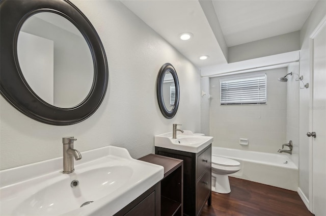 bathroom featuring a sink, toilet, wood finished floors, and bathtub / shower combination