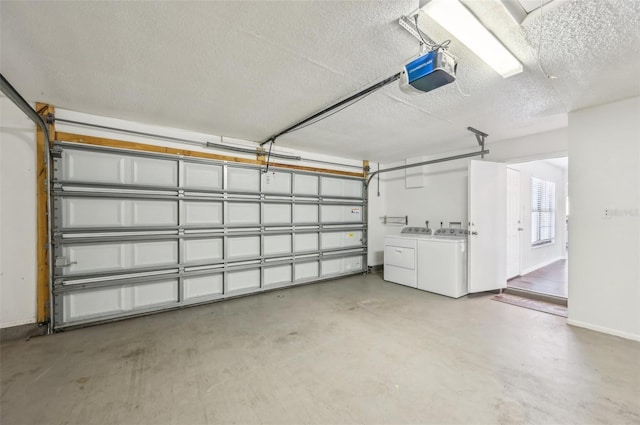 garage with baseboards, a garage door opener, and washer and clothes dryer